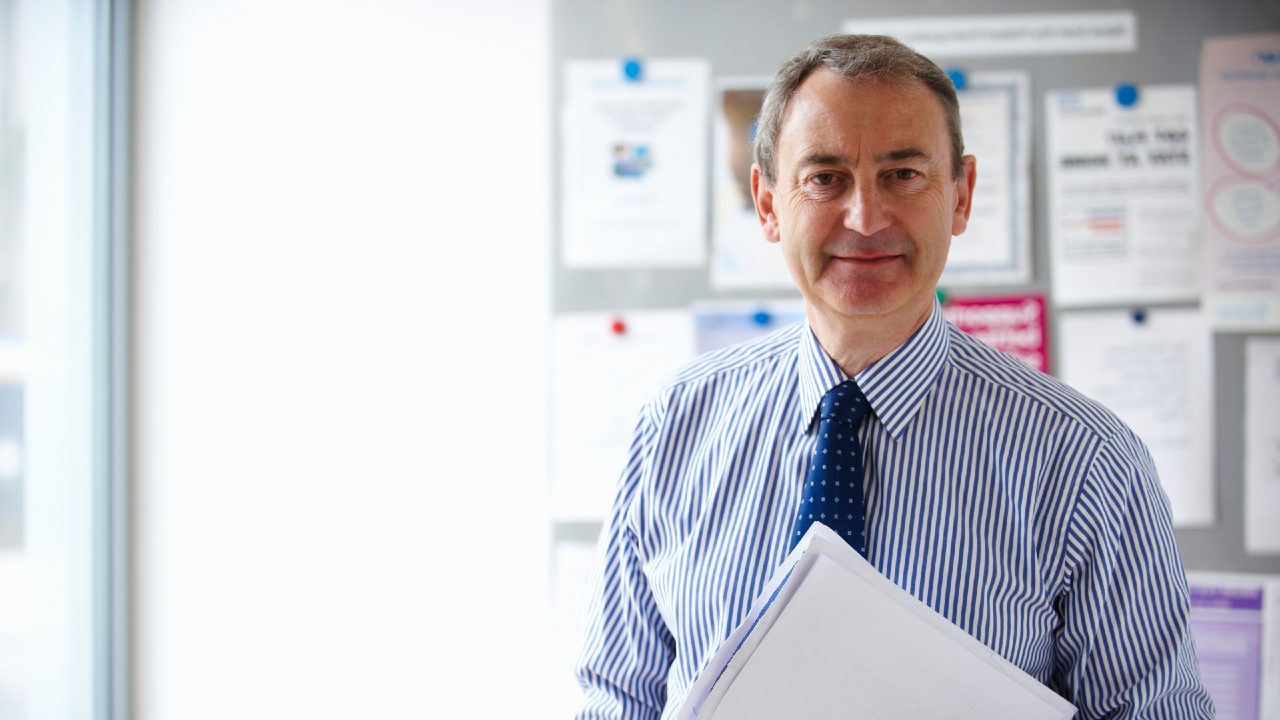 Male gp standing in front of notice board