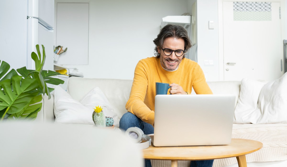 Man at home on sofa with laptop