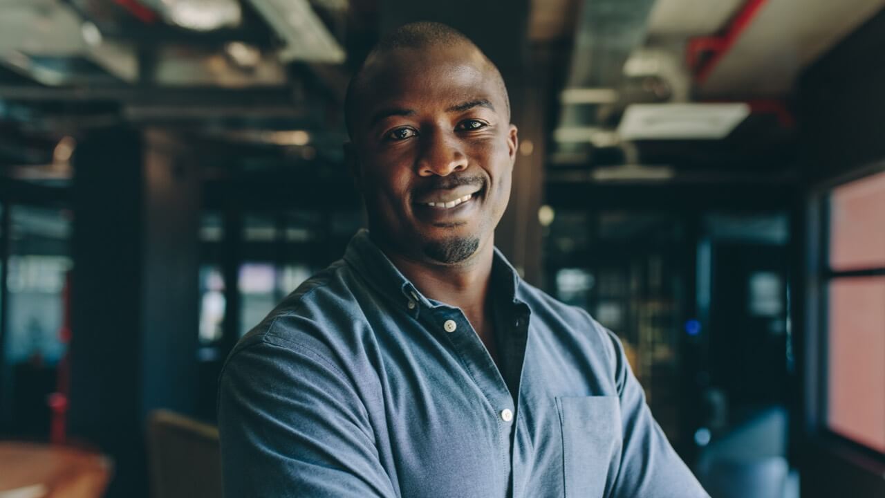 Man smiling in dark modern office