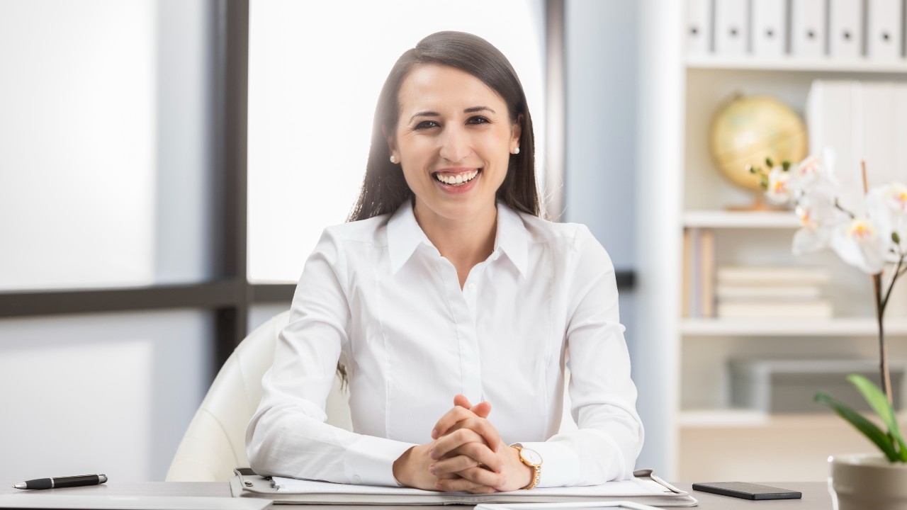 Professional female sat at desk smiling