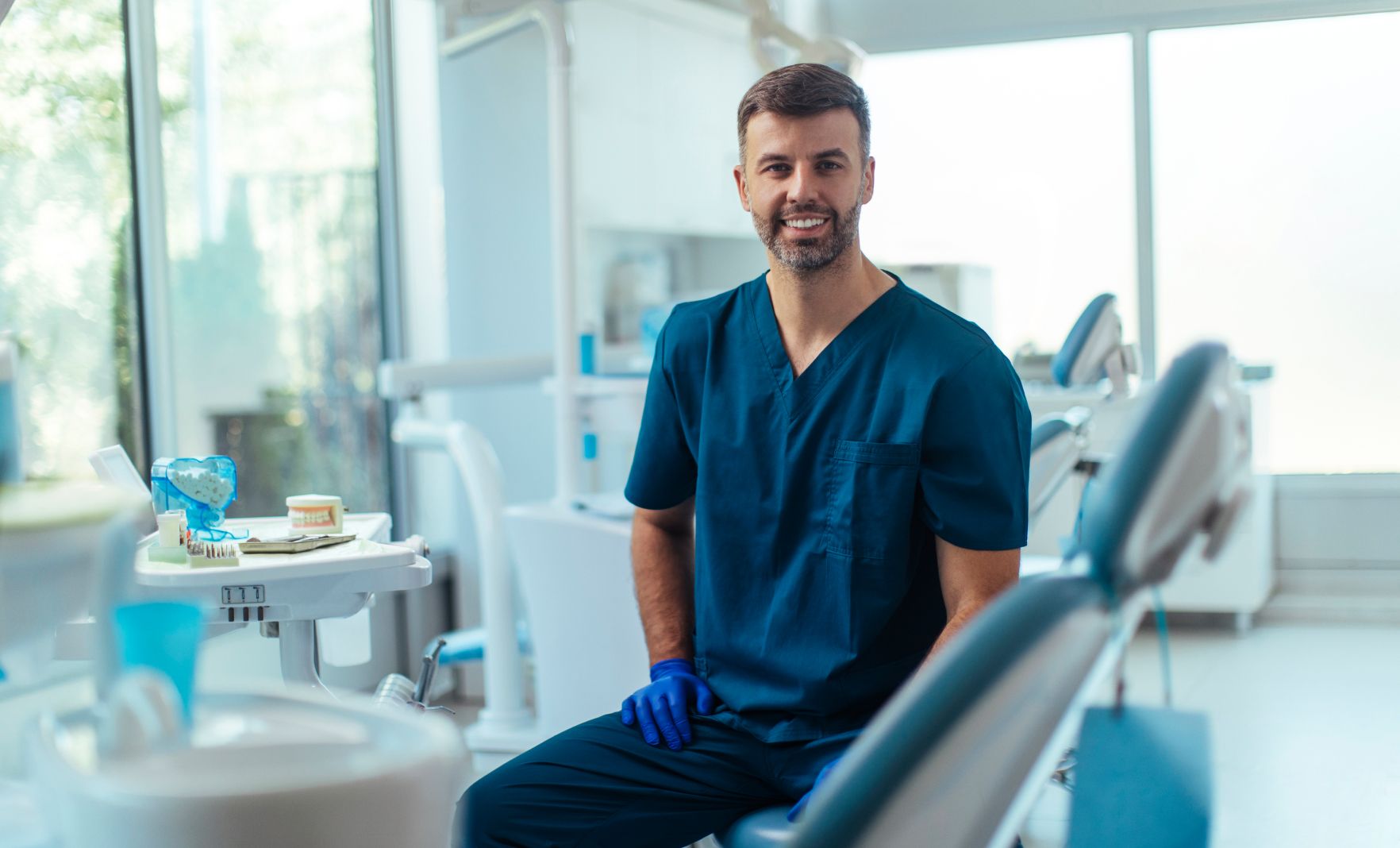 Professional male dentist smiling in clinic