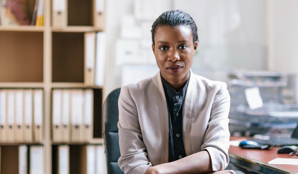 Professional woman in office with bookshelf and files