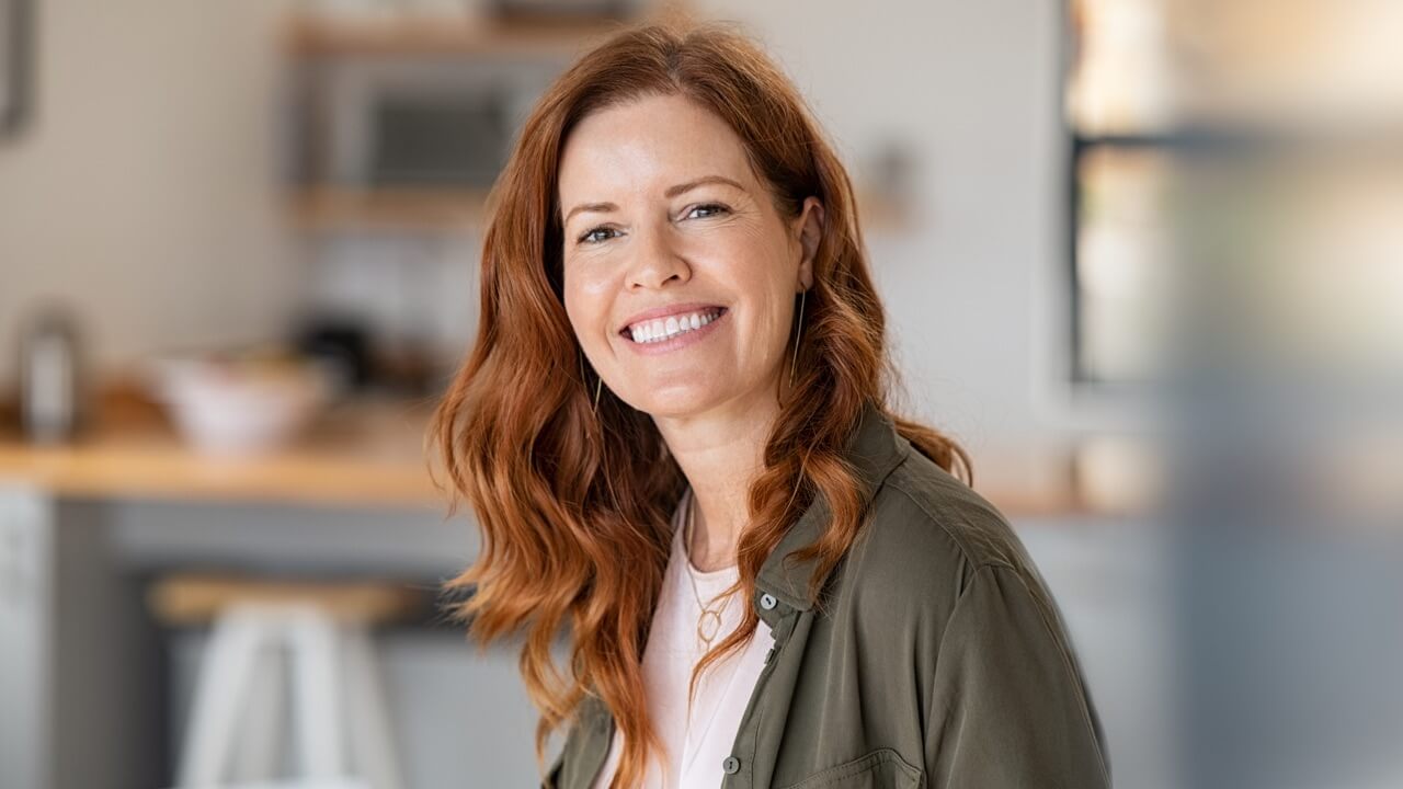 Smiling auburn hair woman in kitchen