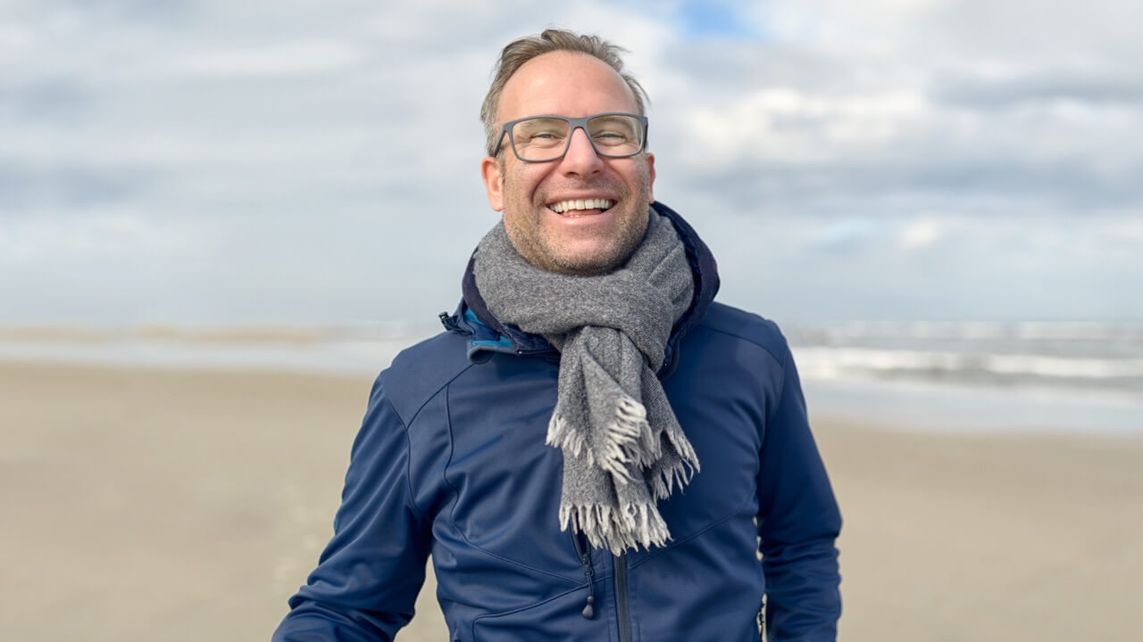 Smiling man on cold beach