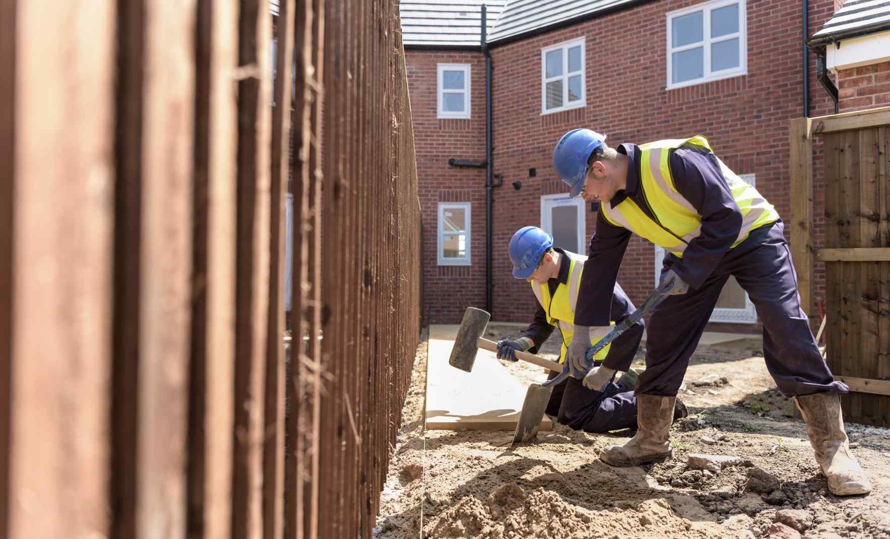 Two male workers doing building work