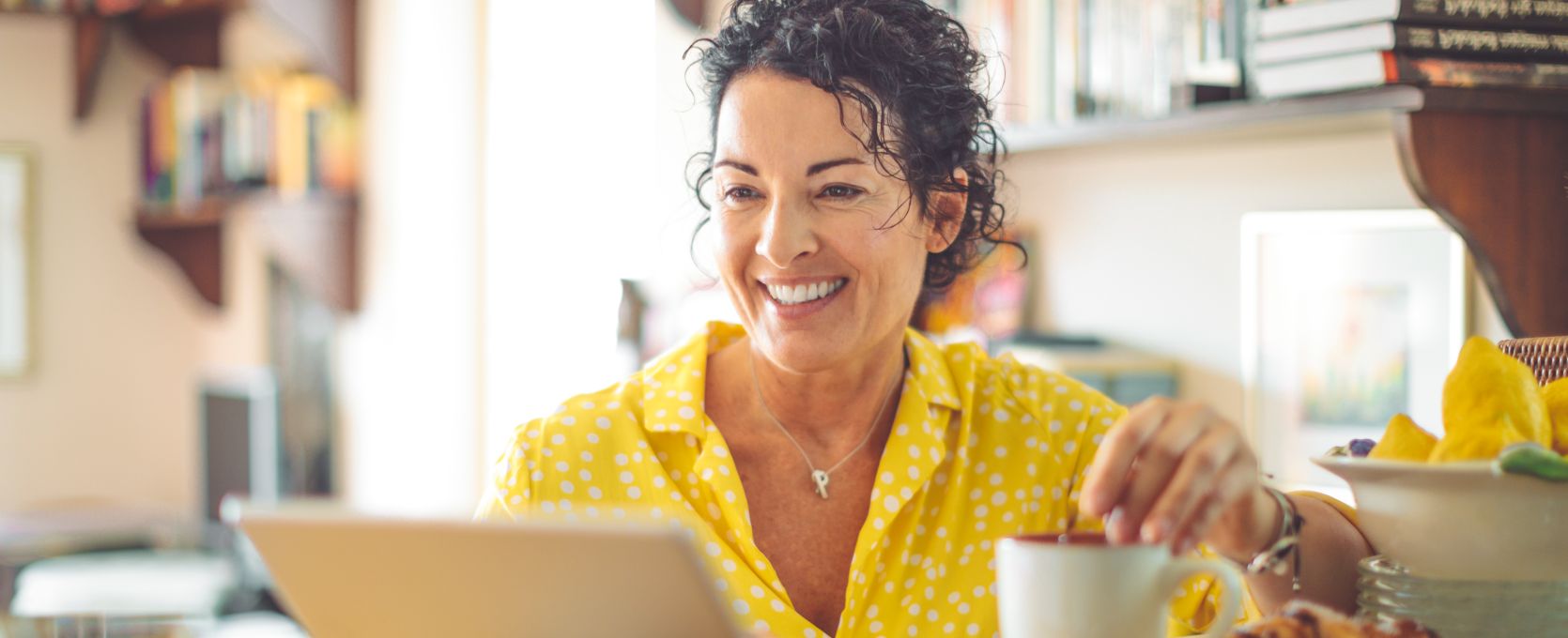 Woman sitting in home office using a tablet