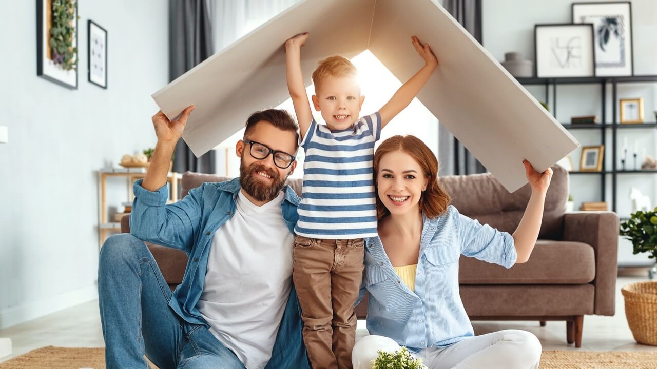 Young family being playful with cardboard roof