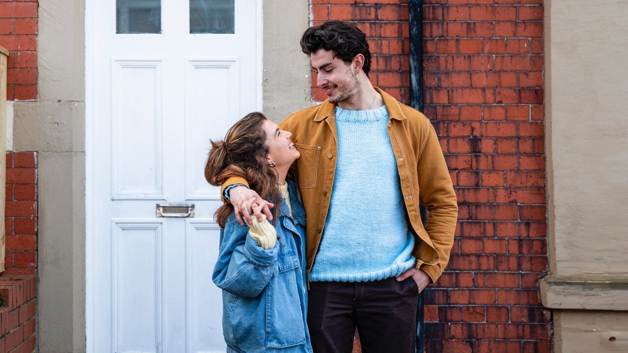 Young happy couple standing outside new home