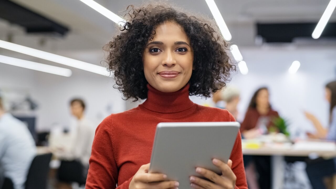 Young woman with tablet in busy office