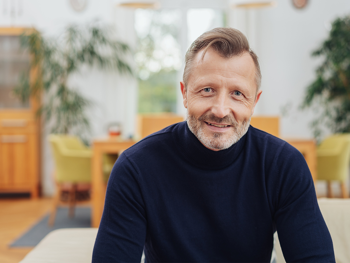 Mature professional male smiling in living room