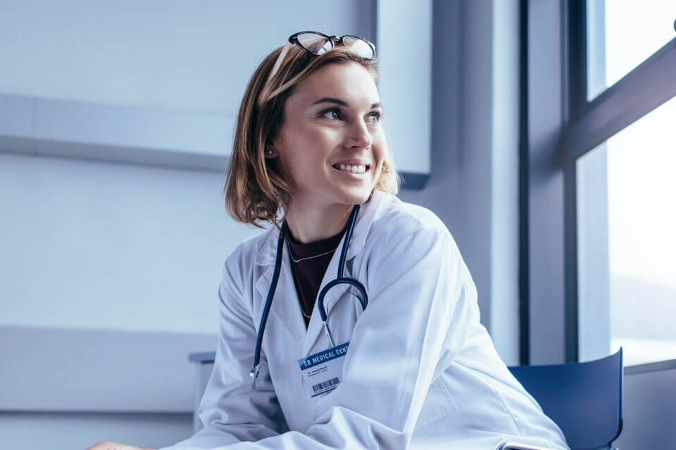 Female doctor sitting on a chair looking out the window