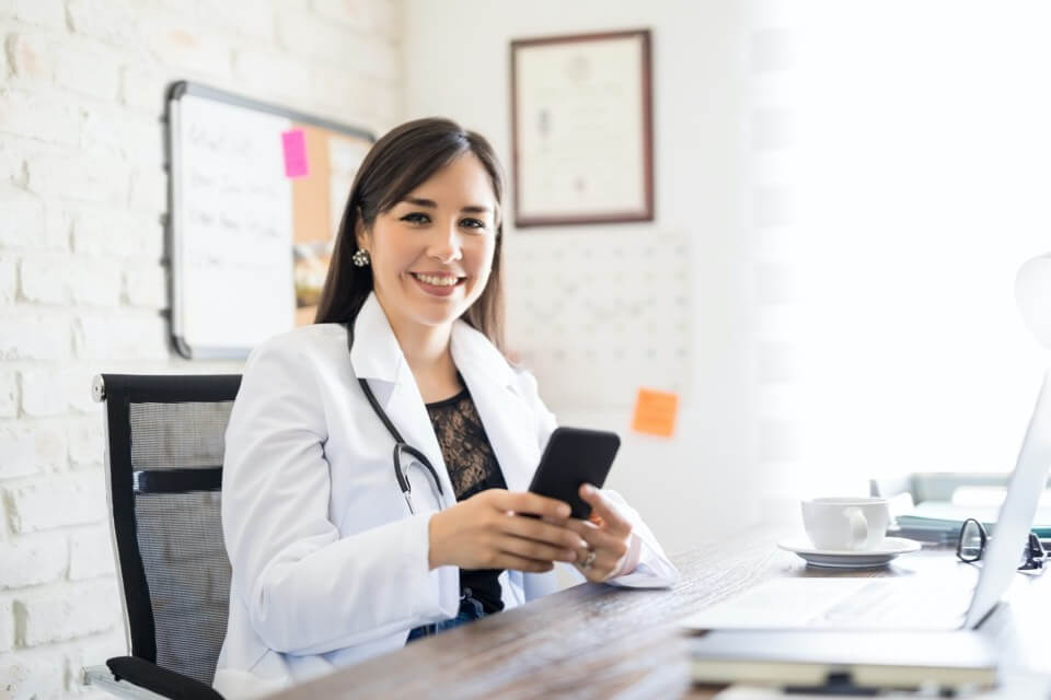 Young female doctor with phone