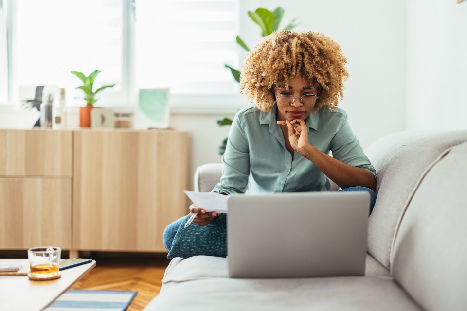 Female student on sofa concentrating on laptop