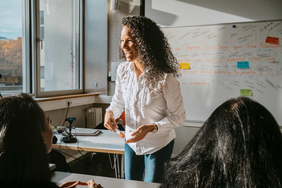 Female teacher addressing students in classroom