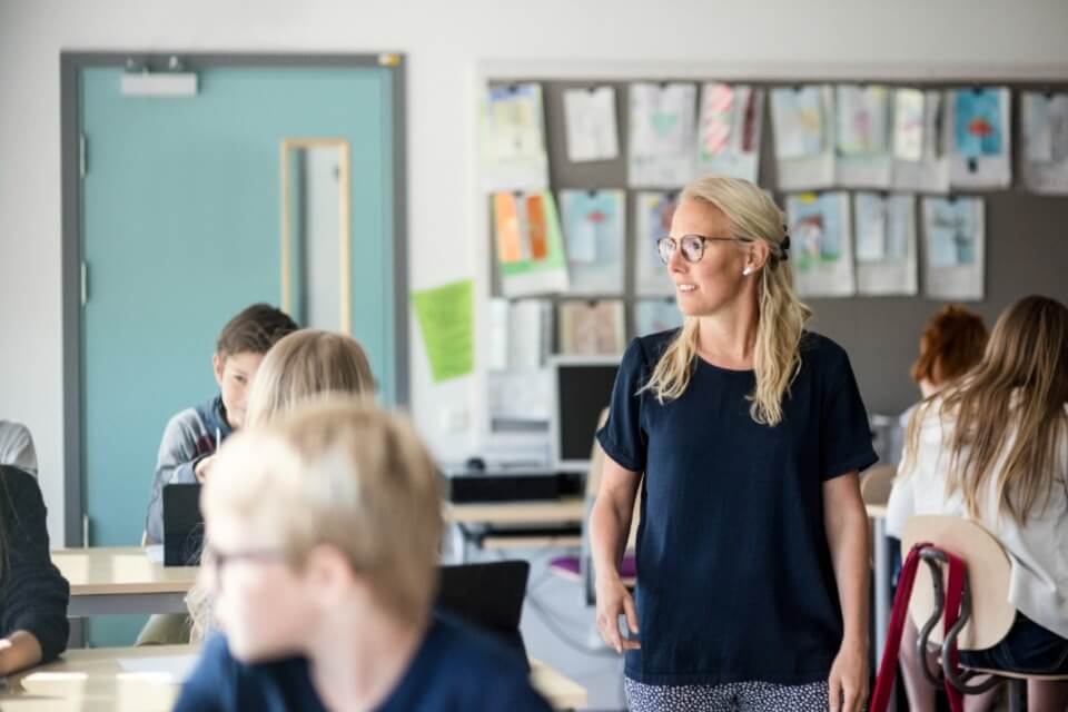 Female teacher walking through classroom