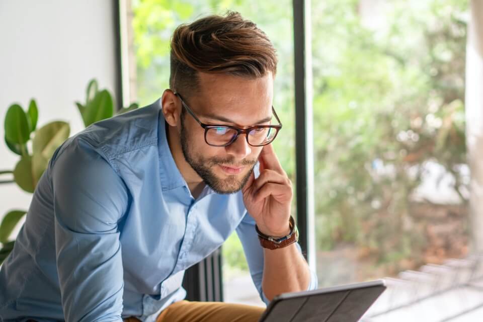 Man in glasses looking at iPad