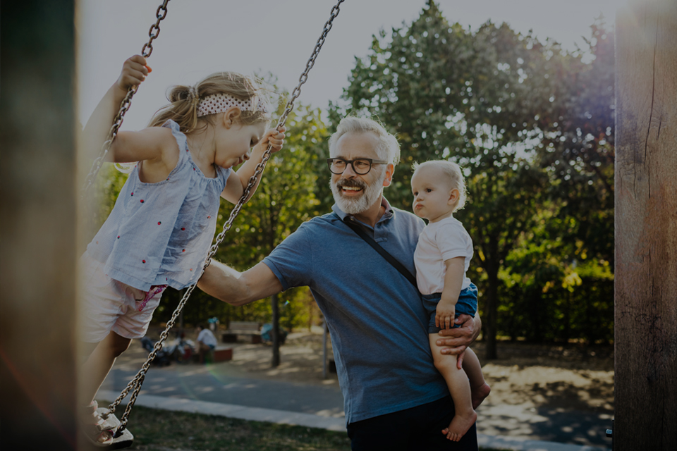 Mature man with grandchildren playing in the park