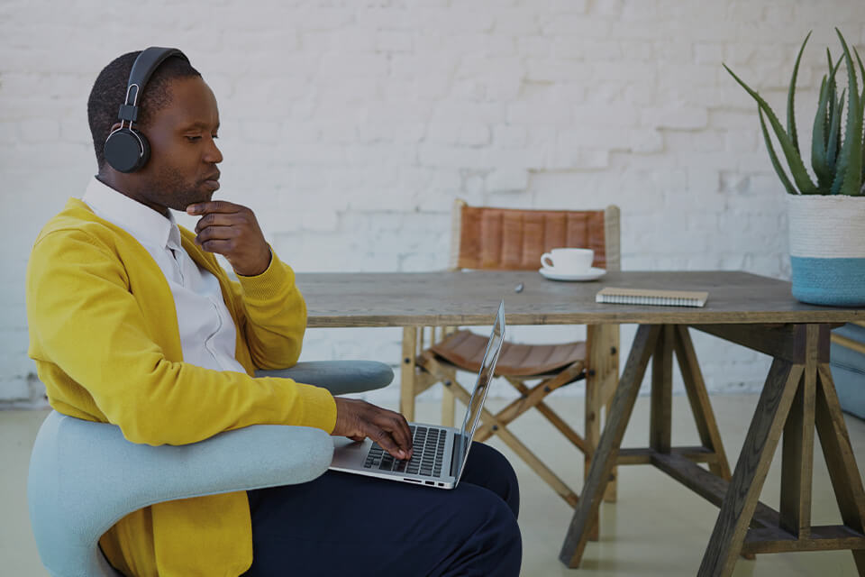 Professional male sitting in thought with laptop