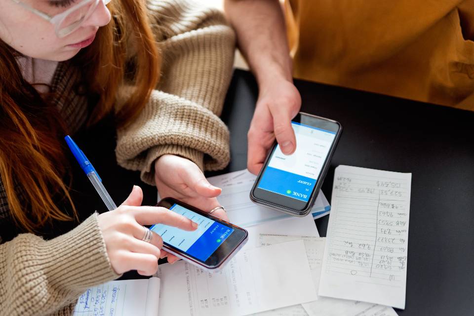 Two students using banking app on phones