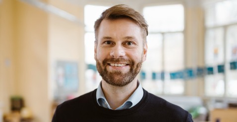 Male teacher smiling in classroom